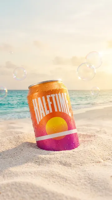 Halftime can half buried in beach sand at golden hour